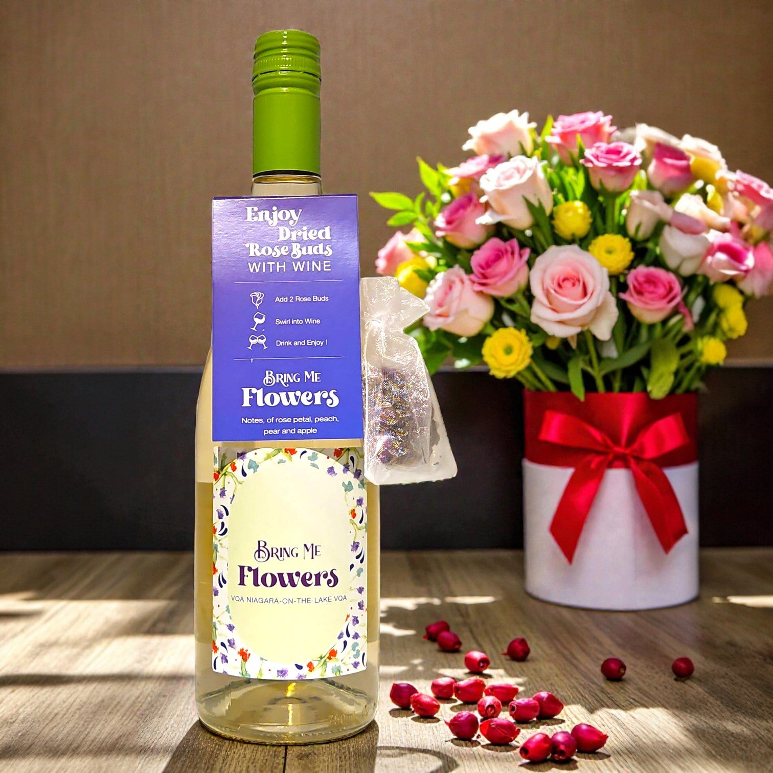 Bottle of wine with a decorative label next to a bouquet of flowers on a wooden surface.