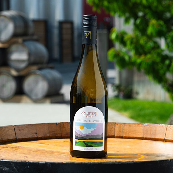 A promotional image featuring a bottle of white wine labeled 'Pillitteri' with the text 'Sunset White' overlayed. 