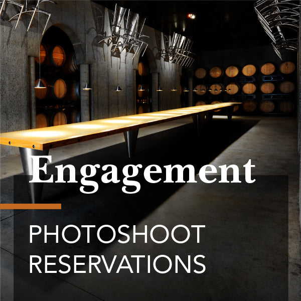 Engagement Photography Shoot at a winery with a long wooden table in a barrel cellar, showcasing text for reservations.
